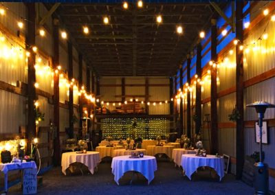 Mood lighting in barn with wedding reception seating